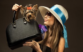 Девушка в шляпе с собакой в черной сумке 