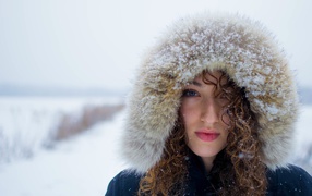 Girl in a snow-covered hood on the street
