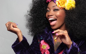 Улыбающаяся темнокожая девушка с цветами в волосах 