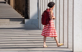 Woman in red striped dress with backpack