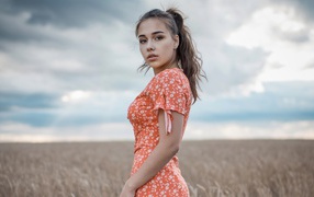 Молодая кареглазая девушка на поле с пшеницей 