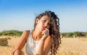 Молодая девушка в белом платье на пшеничном поле