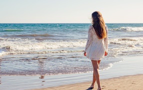 Молодая девушка в белом кружевном платье у моря