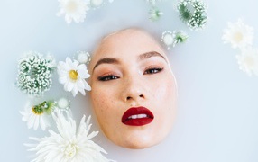 Молодая девушка лежит в ванной с цветами