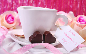Белая чашка кофе с конфетами на День Святого Валентина 14 февраля