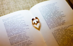 Gold wedding ring lies on an open book