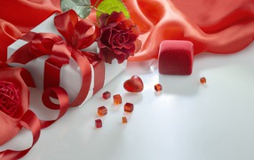 Gifts on a white table with a rose and red cloth