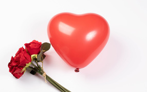 Красный шарик в форме сердца с букетом роз на белом фоне