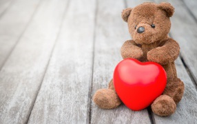 Teddy Bear with a red heart sits on a table
