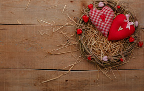 Two hearts made of cloth on a table in a nest