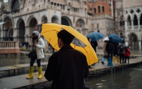 Man with yellow umbrella in the city