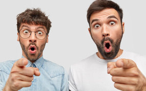 Two surprised men on gray background