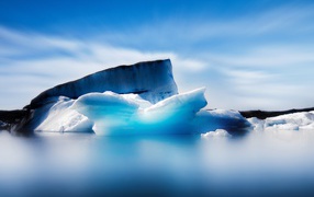 Большой синий айсберг в океане на фоне неба