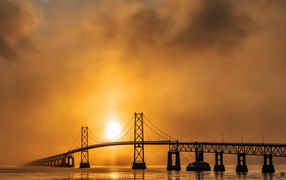 Bridge over the river in the fog at sunrise