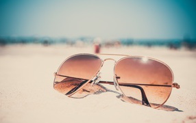 Sunglasses lie on the hot sand