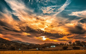 Beautiful sky with clouds at sunrise over a farm