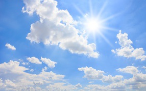 Bright sun in the blue sky with white clouds