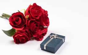 Букет красных искусственных роз с подарком на белом фоне