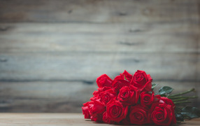Букет красных роз на фоне деревянной стены 