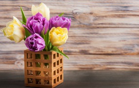 Bouquet of yellow and lilac tulips in a vase