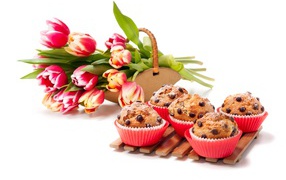 Cupcakes with chocolate and a bouquet of tulips on a white background