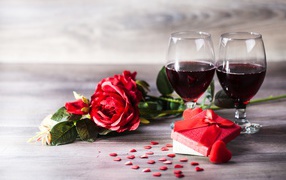 Roses, a gift and two glasses of wine on the table
