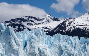 Голубой ледник на фоне заснеженных гор 