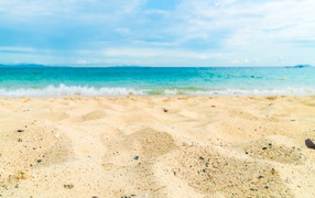 Горячий желтый песок на пляже у океана летом 