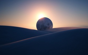 Sunset illuminates a huge moon in the desert