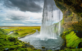 Iceland waterfall flows down from a cliff
