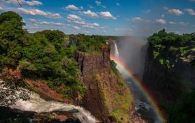 Rainbow over a waterfall on a cliff