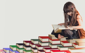 Маленькая девочка сидит на горе книг 