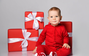 Милый малыш в красном костюме с подарками на новый год 