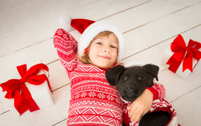 Cute little girl in a new year costume on the floor with a dog