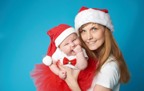 Смешной ребенок в новогоднем костюме на руках у мамы 