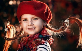 Смешная девочка с косичками в красном берете