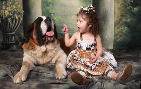 Маленькая красивая девочка с собакой породы сенбернар