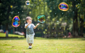 Little boy catches soap bubbles