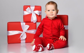 Little boy in a red suit with gifts