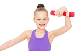 Little girl is engaged with dumbbells on a white background