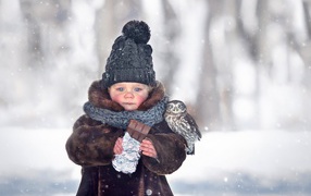Little girl with a chocolate bar in her hands on the street in winter