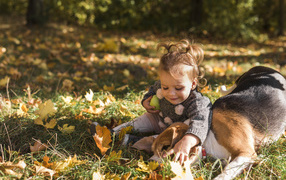 Little girl with a dog in the autumn forest