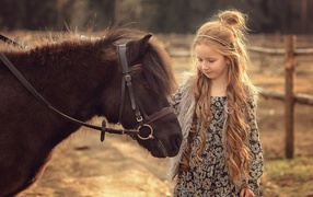 Маленькая девочка с пони на ферме