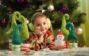 Little girl with toys under the tree
