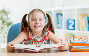 Улыбающаяся маленькая девочка с книгой 