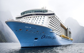 Большой круизный лайнер Ovation of the Seas заплывает в фьорд 