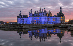 Chambord castle reflected in the water at dusk, France