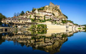 Houses on a rock by the water under a blue sky, France