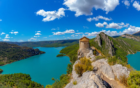 Old building on top of a cliff on the background of a river under a blue sky, Spain
