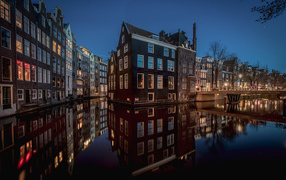 Tall houses between canals in the evening, Amsterdam. Netherlands